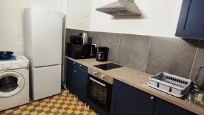 Una cocina compacta equipada con lavadora, microondas y horno.