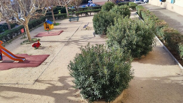 Un parque infantil con tobogán y columpios.