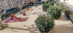 A playground with a slide and a swing set.