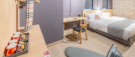Una camera d'albergo moderna con un letto, una scrivania, una sedia e un lampadario.