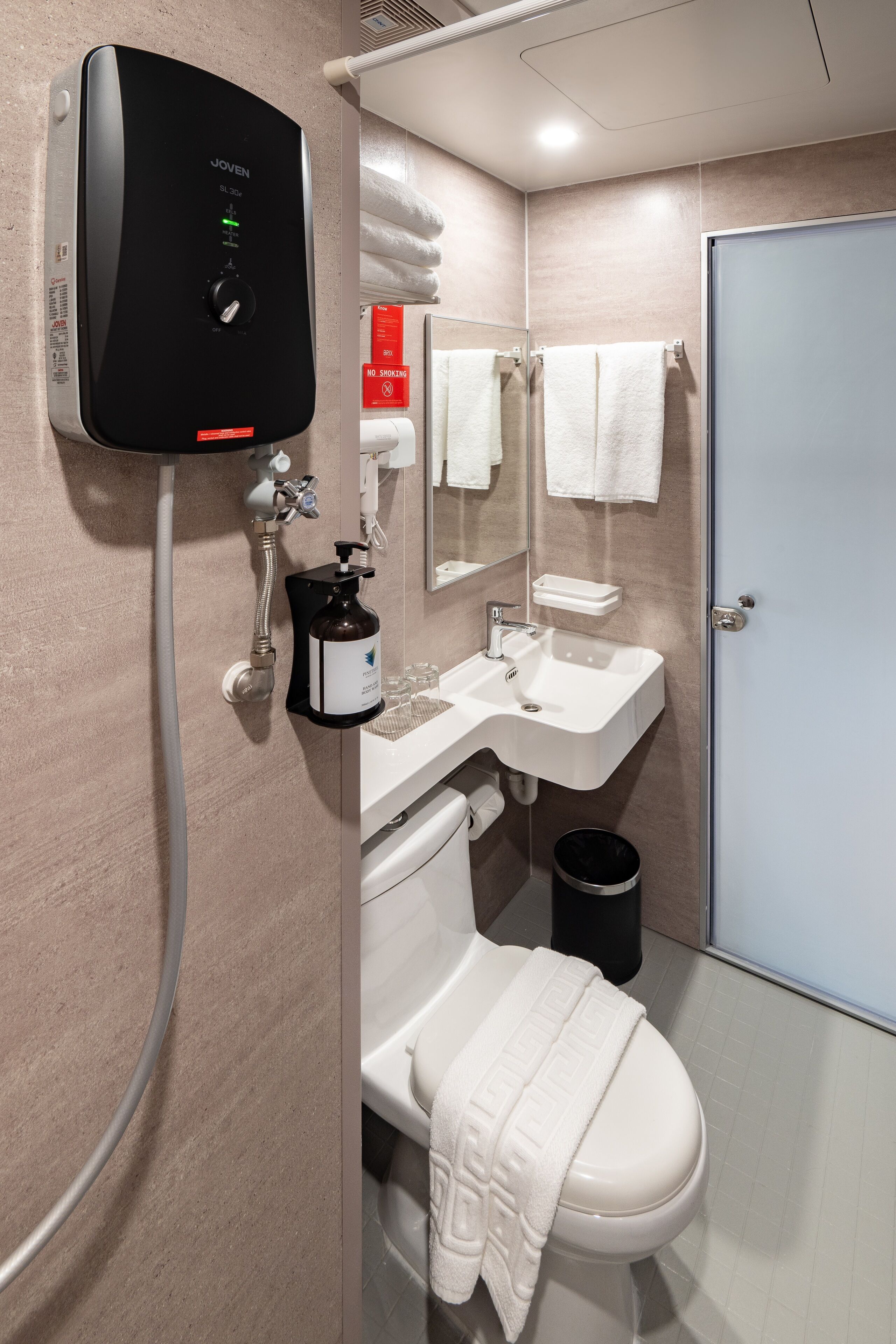 A modern bathroom with a shower, toilet, and sink.