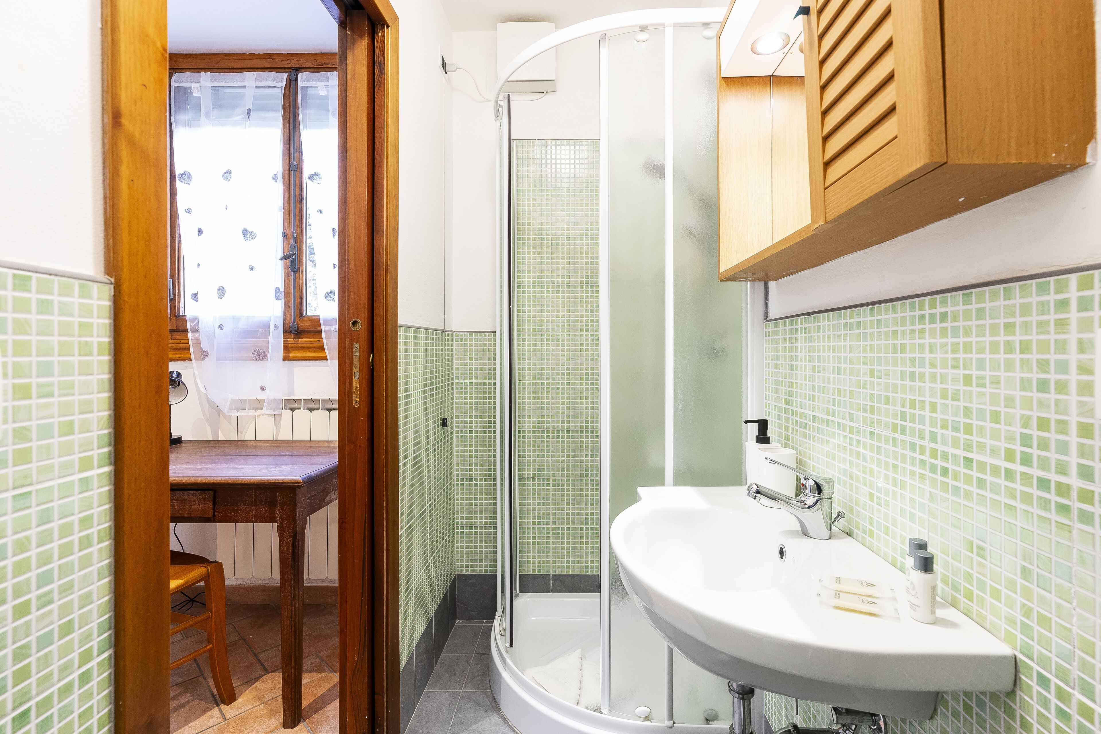 Une salle de bain avec une douche, un lavabo et une porte en bois.