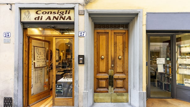 Un escaparate con una puerta de madera y un letrero que dice 'Consigli di ANNA'.
