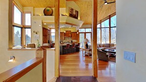 A spacious interior with a wooden floor, a kitchen area with bar stools, and a seating area with a sofa and coffee table.
