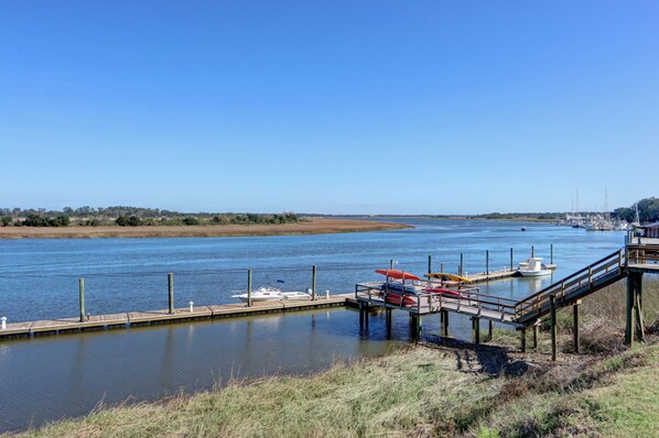 Un río tranquilo con un muelle y barcos.