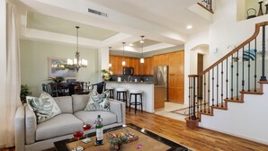Un salón amplio con sofá, mesa de centro y una cocina al fondo.