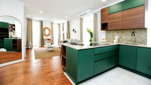 Una cocina moderna con armarios verdes, encimera de granito y horno empotrado.