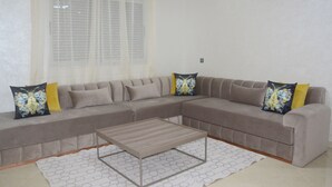 Una sala de estar con un sofá modular, una mesa de centro y un tapete estampado.