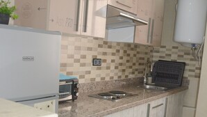 Una cocina con horno empotrado, microondas, tostadora y lavabo.