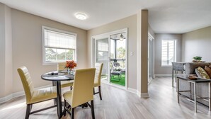 A dining area with a round table and chairs, a view to an outdoor patio, and a kitchen area with a countertop and seating. - North Myrtle Beach Oasis w/ Community Pool! (North Myrtle Beach)