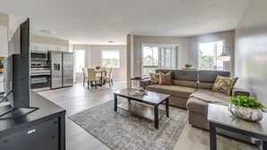 A modern living room with a sofa, coffee table, and a TV stand. - North Myrtle Beach Oasis w/ Community Pool! (North Myrtle Beach)