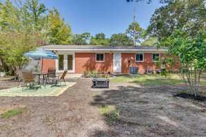 A single-story brick house with a covered patio, a small garden, and a sign in front. - Florida Escape w/ Patio & Fire Pit, Near Beaches! (Fort Walton Beach)