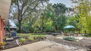 Ein Garten mit Terrasse, Gartenmöbeln und einem Gartenbereich.