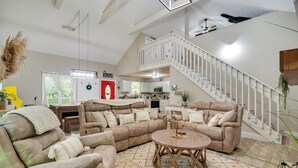A spacious living room with a large sectional sofa, a round coffee table, and a staircase leading to an upper level. - Smoky Mtn Home w/ Hot Tub: 10 Mi to Dollywood! (Sevierville)