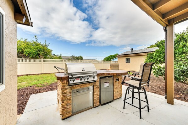 An outdoor kitchen with a grill, oven, and seating area. - Sunny San Diego Home w/ Private Yard & Grill! (San Diego)