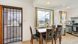 A modern kitchen with a dining area, featuring a large window, stainless steel appliances, and a view of the cityscape. - Sunny San Diego Home w/ Private Yard & Grill! (San Diego)