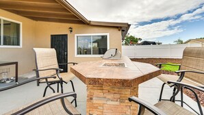 An outdoor patio with a stone table and four chairs, a black door, and a window. - Sunny San Diego Home w/ Private Yard & Grill! (San Diego)