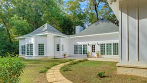A two-story house with a covered porch and a stone pathway leading to the entrance.