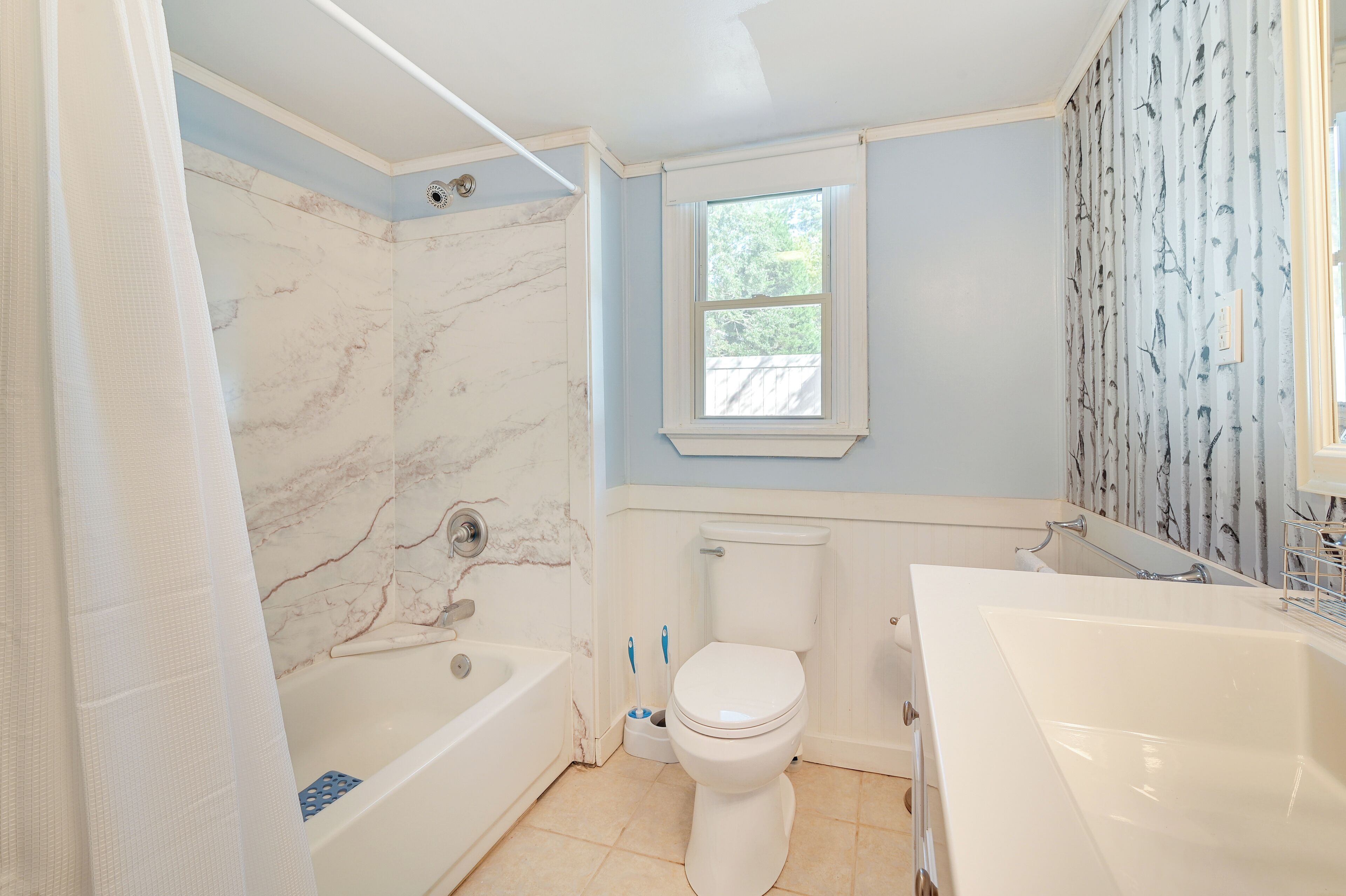 A bathroom with a bathtub, toilet, and sink.