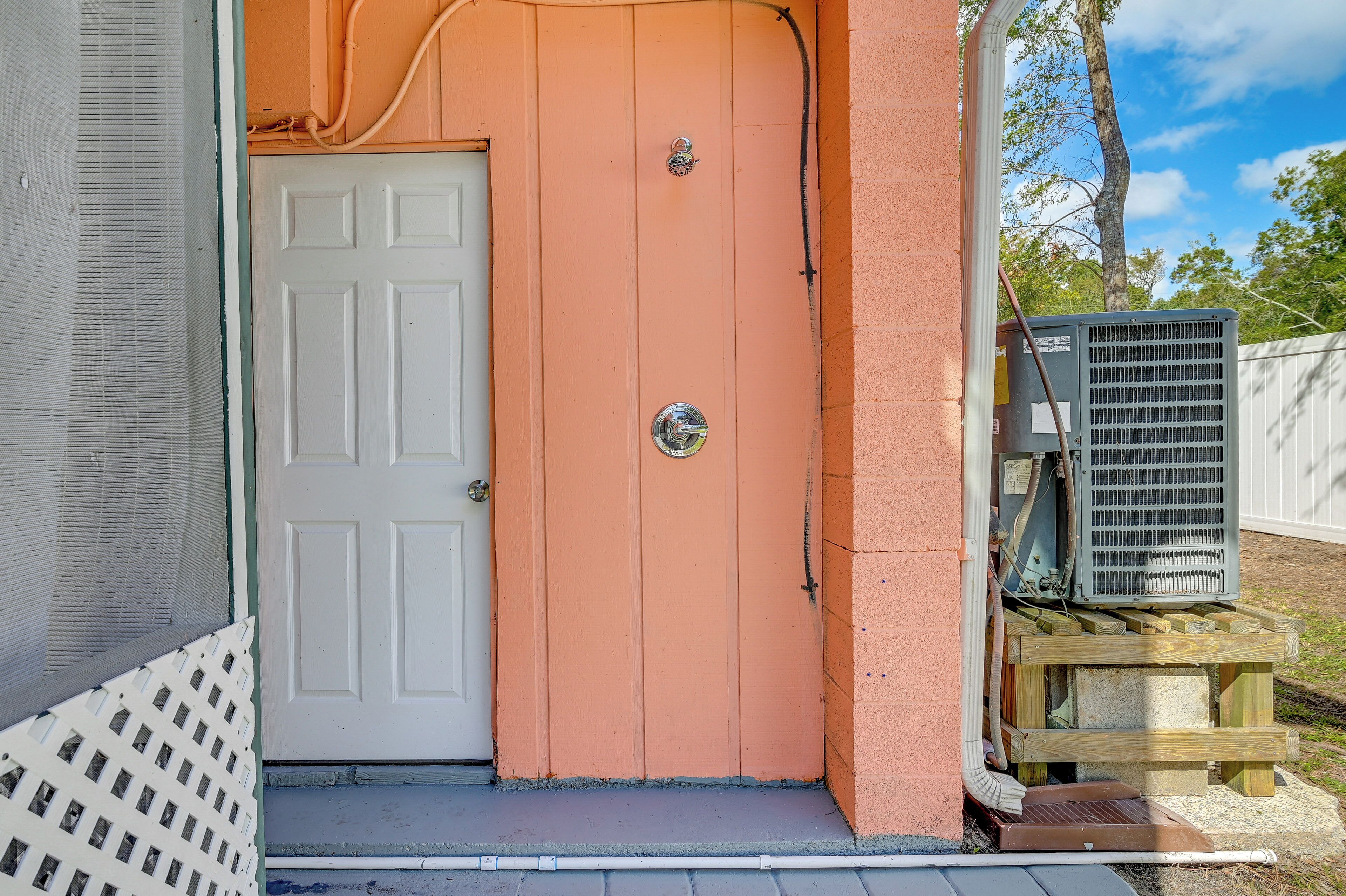 A house with a white door and an orange exterior wall.