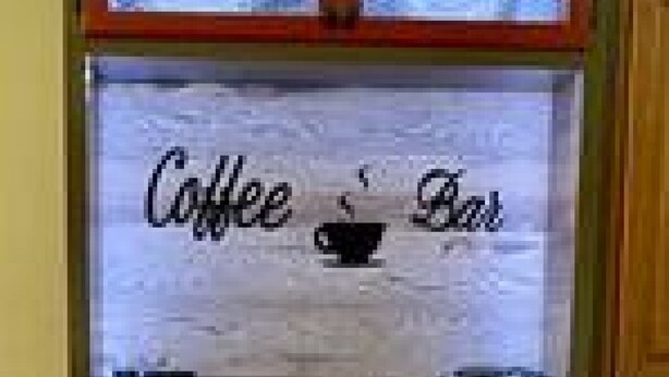A coffee bar with a sign reading "Coffee Bar" and various coffee-making equipment.
