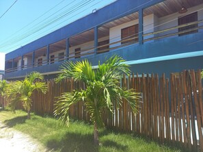 A building with a blue exterior, multiple windows, and a wooden fence.