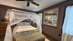 A bedroom with a four-poster bed, a ceiling fan, a decorative wall piece, and a nightstand. - Beautiful 3 BR Cedar Ranch Home with Awesome Master and Cooks Kitchen  (Colchester)