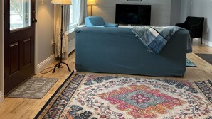 A modern bedroom with a large bed, a TV, and a patterned rug. - Beautiful 3 BR Cedar Ranch Home with Awesome Master and Cooks Kitchen  (Colchester)