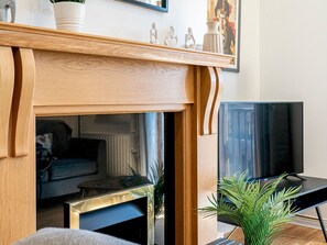 Ett modernt vardagsrum med en öppen spis, en tv och ett soffbord.