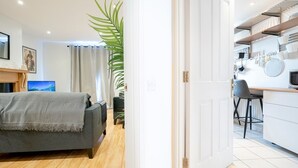 Espaço compacto com cama, escrivaninha e cozinha compacta.