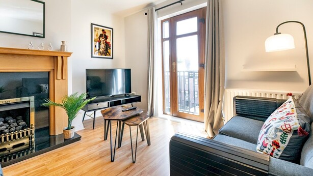 Uma sala de estar moderna com lareira, TV, sofá e área de refeições.