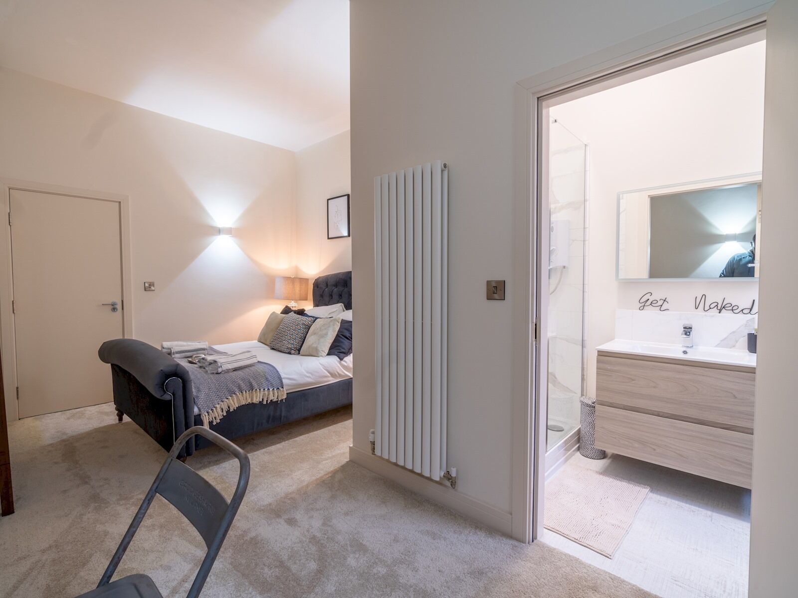 Een slaapkamer met een bed, een bedlampje en een radiator.