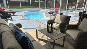 An outdoor patio with wicker furniture, a pool, and a view of the backyard. - Backyard Oasis, calm, quiet and peaceful. Just pack and come enjoy.  (Port St. Lucie)