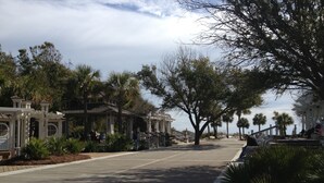 A street lined with trees and buildings, including a white structure with columns and a covered area. - Cute Condo close to Coligny Beach (Hilton Head Island)