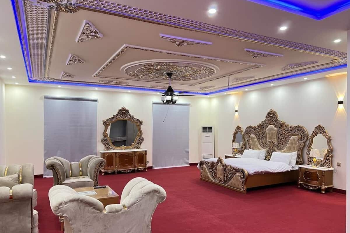 Ein luxuriöses Schlafzimmer mit einem großen Bett, einem aufwendig verzierten Kopfteil und einem roten Teppich.