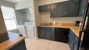 A compact kitchen with dark cabinets, a wooden countertop, and a dishwasher. - Comfortable Coastal 2 BDRM home - 5 mins to downto (saint marys)