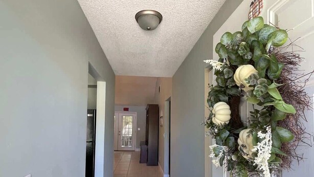 A hallway with a door on the right, a light switch on the left, and a ceiling light fixture. - Comfortable Coastal 2 BDRM home - 5 mins to downto (saint marys)