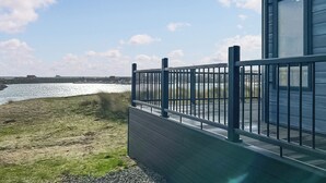 A coastal building with a metal railing, a grassy area, and a body of water in the background. - 2 bedroom accommodation in Peterhead (Peterhead)