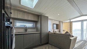 A modern interior with a kitchen, seating area, and a large window. - 2 bedroom accommodation in Peterhead (Peterhead)
