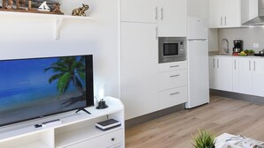 Una cocina moderna con armarios blancos, microondas y cafetera.