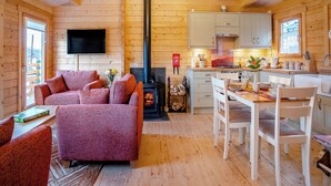 A cozy cabin interior with a living room, fireplace, dining area, and kitchen. - 2 bedroom accommodation in Garnant Ammanford (Garnant Ammanford)