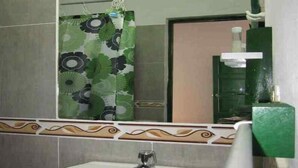 A bathroom with a sink, mirror, and green shower curtain. - Hotel Esquina Colonial (Villa de Leyva)