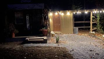Un edificio rústico con un letrero que dice 'Country Cottage', una puerta de madera y luces de cuerda.