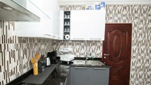 Une cuisine moderne dotée d’un îlot central, de meubles de rangement intégrés et d’un crédence décorée.