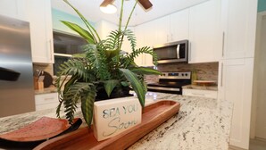 A kitchen with white cabinets, a microwave, and a stainless steel refrigerator.