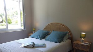 A bedroom with a bed, two pillows, a bedside lamp, and a window. - Maison à la Montagne Avec la vue sur le Montcalm Avec son Jardin Clôturé (Auzat)