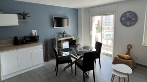 Eine moderne Küche mit Essbereich, einem Flachbildfernseher und Blick ins Freie.