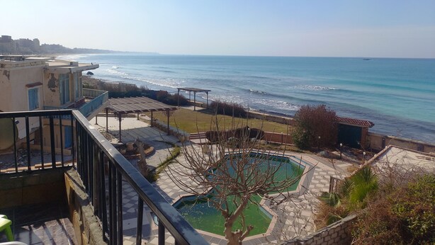 Vista costera con piscina y playa.