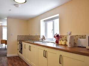 Eine Küche mit einer Holzauskładung, einem Fenster und einem Prolex Wasserspender.