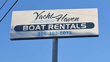 A sign for Yacht Haven Boat Rentals with a phone number.